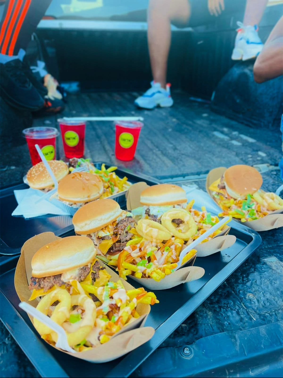 Multiple RAK'ENG burger meals served on a tray with fizz drinks
